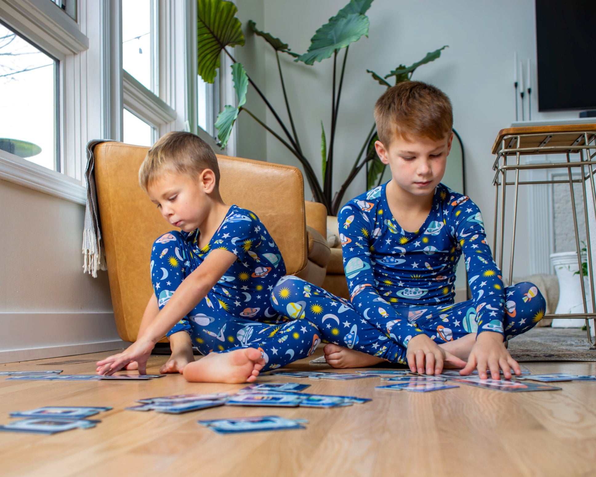 Earthly Threads space-themed two-piece pajama set, featuring a vibrant print of planets, moons, and stars, crafted from buttery soft, breathable bamboo fabric, available in short or long sleeve options for comfort during hot summer days and cold winter nights. 